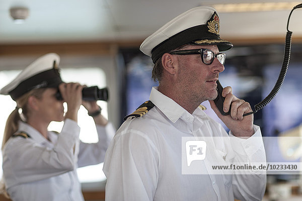 Ship captain on bridge talking on radio