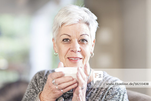 Porträt einer weißhaarigen Seniorin mit Tasse
