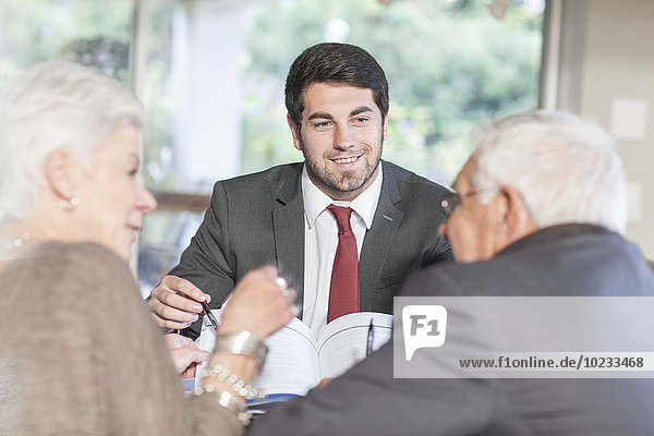 Seniorenpaar zu Hause bei einem Treffen mit dem Verkäufer
