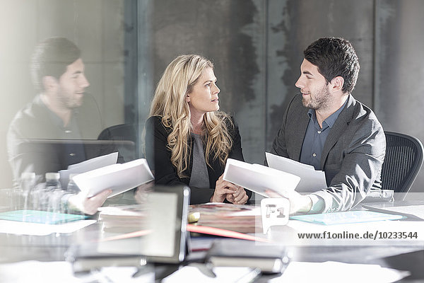 Businessman sitting face to face with woman at desk