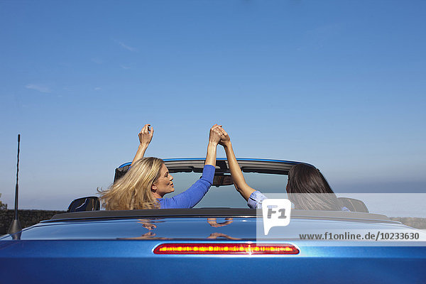 Südafrika  zwei Frauen Hand in Hand in einem Cabriolet
