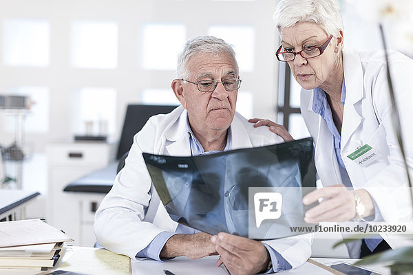 Two doctors at desk discussing x-ray