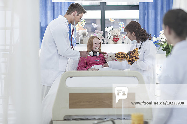 Ärzte untersuchen Mädchen im Krankenhausbett