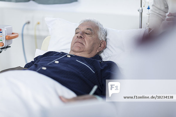 Senior man sleeping in a hospital bed