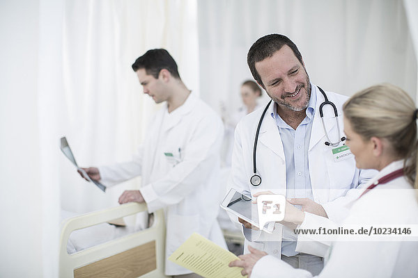 Ärzte mit digitalem Tablett im Krankenhauszimmer
