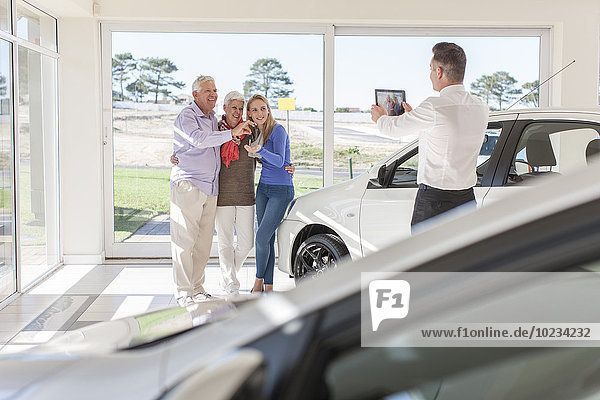 Autohaus fotografiert glückliche Familie mit Autoschlüssel