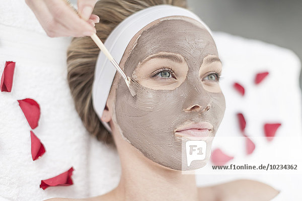 Cosmetician applying beauty mask