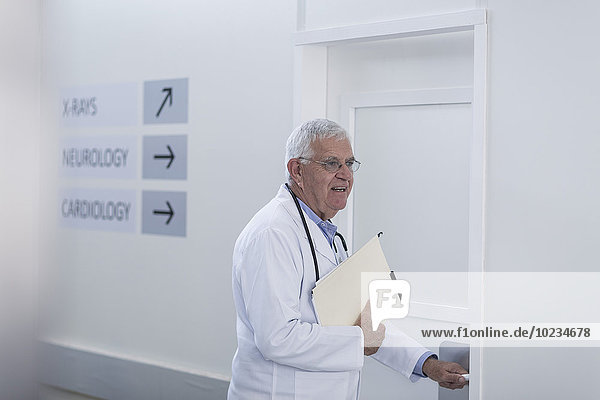 Doctor in hospital corridor opening door