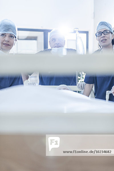 Chirurgen am Krankenhausbett mit Patientin