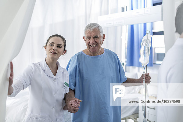 Nurse supporting senior patient in hospital