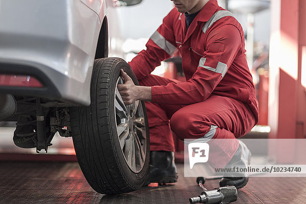 Car mechanic at work in repair garage  changing tires