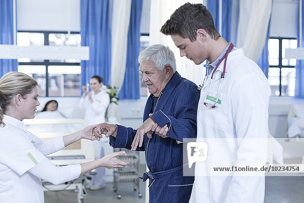 Hospital staff supporting senior patient