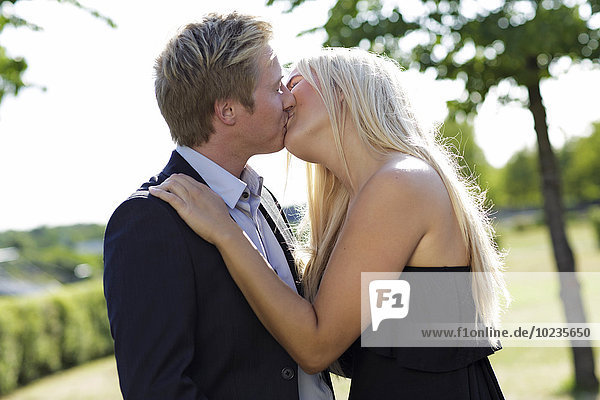 Elegantes junges Paar beim Küssen im Freien