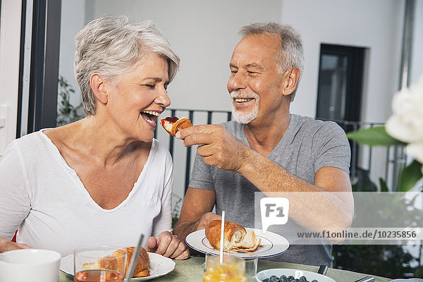Elderly couple having breakfast at balcony