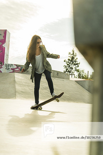 Junge Frau beim Skateboarden im Skatepark