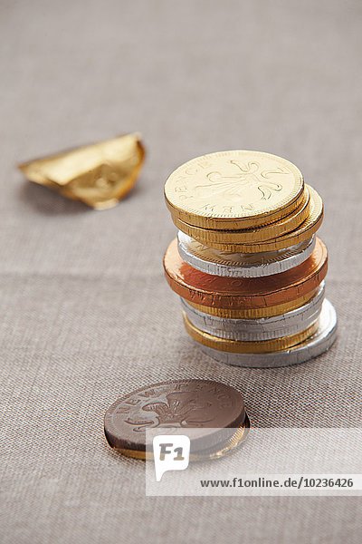 Gestapelte Schokoladenmünzen in Folie auf einer Tischdecke