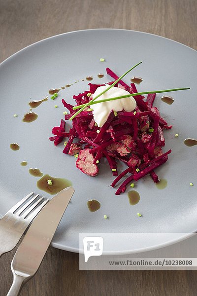 Rote-Bete-Salat mit Tafelspitz auf Teller mit Kürbiskernöl  Schnittlauch und Creme fraiche