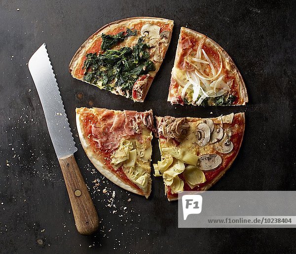 Pizza mit Spinat  Champignons  Artischocken  Parmaschinken  Zwiebeln und Thunfisch  angeschnitten