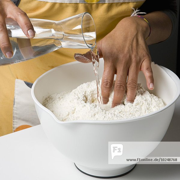 Adding the water to the flour for the dough