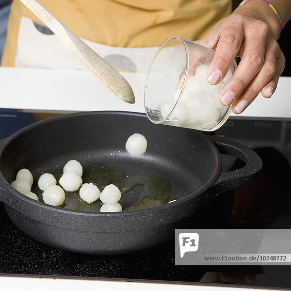 Cooking the grelot onions in a frying pan with oil
