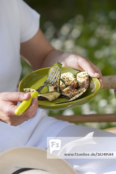 Außenaufnahme essen essend isst Mensch Zucchini gegrillt freie Natur