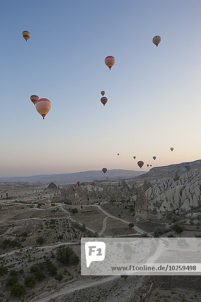 Heißluftballons fliegen über Felslandschaft