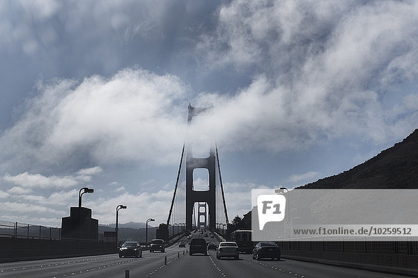 Autos auf der Golden Gate Bridge gegen bewölkten Himmel