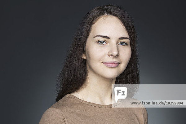 Porträt der schönen jungen Frau über grauem Hintergrund