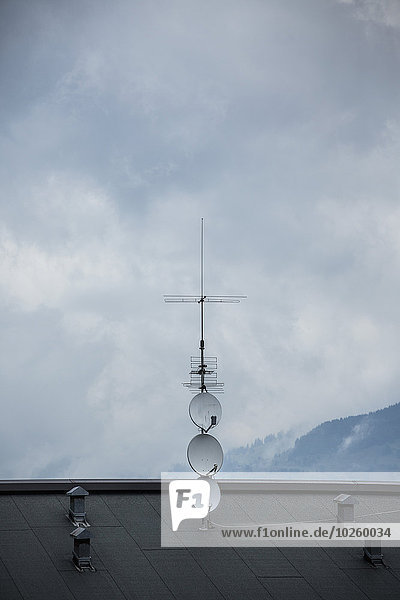 Fernsehantenne auf dem Dach gegen bewölkten Himmel