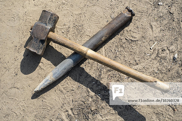 Hammer und Meißel auf Sand