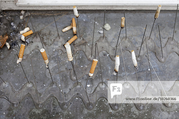 Hochwinkelansicht von Zigarettenstummeln in Stäbchen auf Wasser