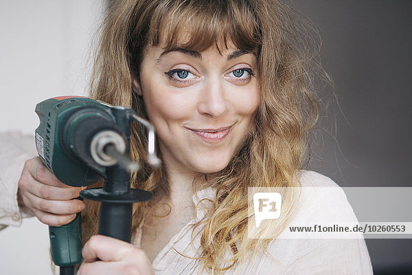 Interior,zu Hause,junge Frau,junge Frauen,Portrait,halten,Bohrmaschine,Bohrer,Hoffnung,Stärke