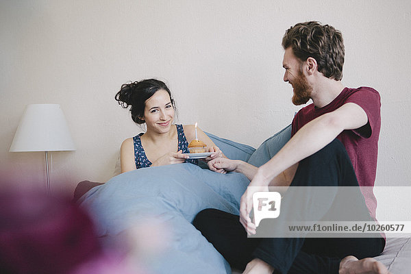 sitzend,nebeneinander,neben,Seite an Seite,junge Frau,junge Frauen,Portrait,Mann,Fröhlichkeit,halten,Bett,Geburtstag,Kerze,cupcake