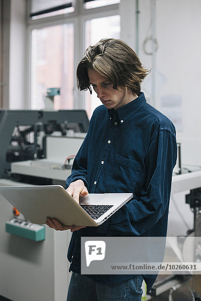 benutzen,Notebook,Technischer Beruf,jung,Fabrikgebäude