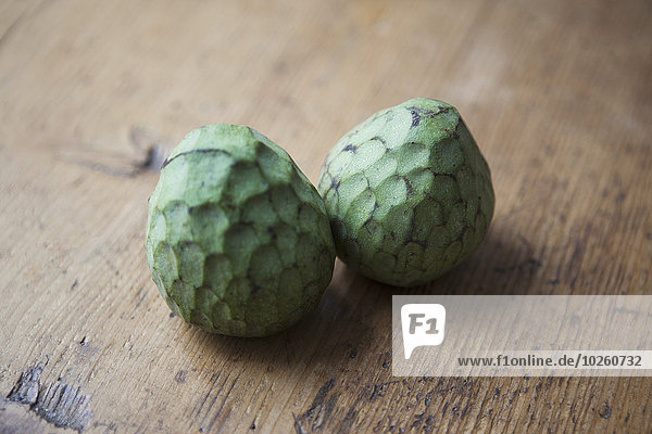 Whole cherimoyas on wooden table