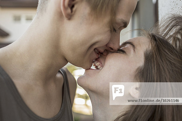 Side view of passionate couple kissing outdoors