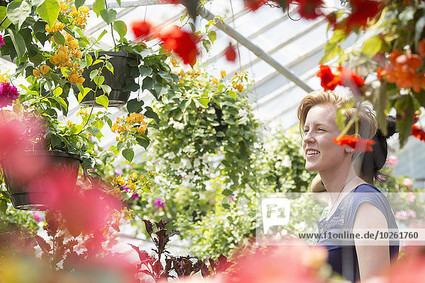 junge Frau junge Frauen sehen Blume Korb hängen bunt Pflanze Garten