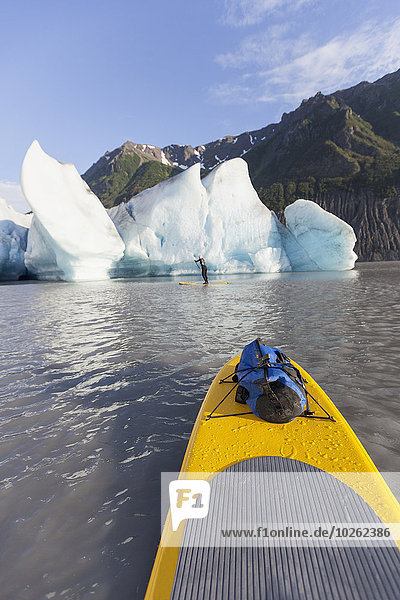 POV from a stand up paddleboarder of Grewingk Glacier and fellow paddleboarder  Kachemak Bay State Park  Southcentral Alaska