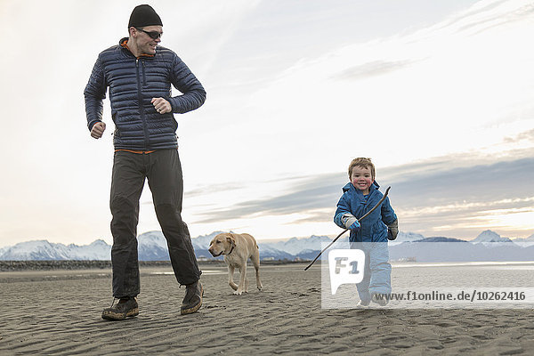 Father and son play on beach on the Homer Spit  Kenai Peninsula  Southcentral Alaska.