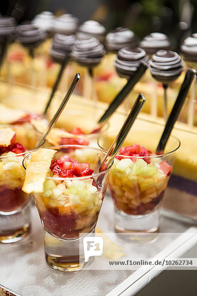 Close-up of Glasses of Fruit Cocktail and Chocolate Lollipops on Dessert Table