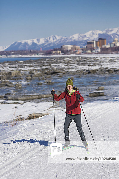 A young woman skate skiing down the Tony Knowles Coastal Trail  Anchorage  Southcentral Alaska  USA.