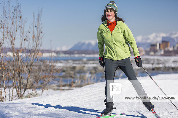 A young woman skate skiing down the Tony Knowles Coastal Trail  Anchorage  Southcentral Alaska  USA.