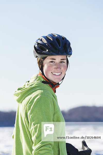 Portrait of a smiling young woman wearing a black bicycle helmet  Anchorage  Southcentral Alaska  Winter  USA