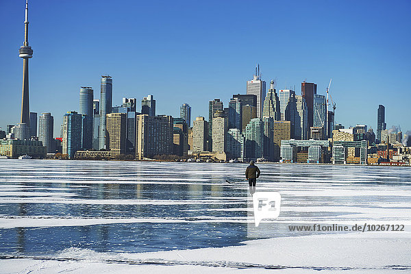Hockey player and city skyline from Ward's Island; Toronto  Ontario  Canada