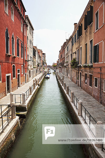 A narrow canal lined with residential buildings; Venice  Italy