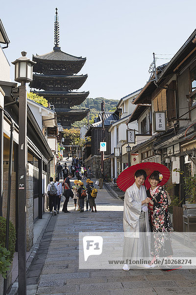 entfernt Pose Regenschirm Schirm Straße unterhalb rot jung Japan japanisch Kimono Kyoto schmal Pagode