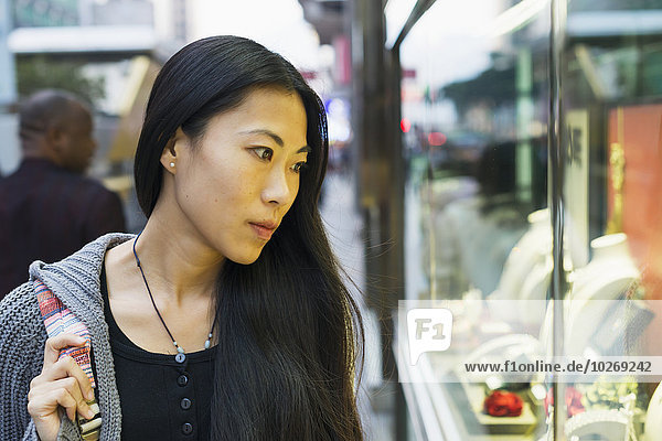 A young woman window shopping at the retail shops along the street  Kowloon; Hong Kong  China
