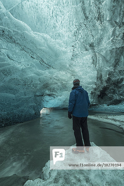 Person standing under the Vatnajorkull ice cap; Iceland