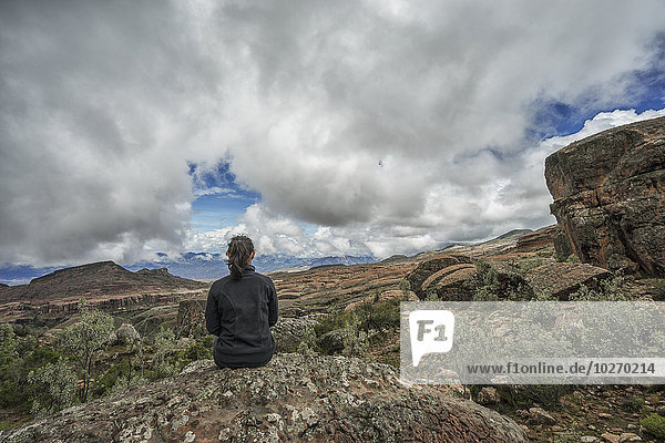 A woman sits on a rock looking out over the beautiful landscape of Toro Toro National Park; Bolivia