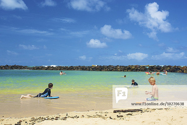 Kinder spielen im Wasser in der Nähe des Ufers  Lydgate Park; Kauai  Hawaii  Vereinigte Staaten von Amerika